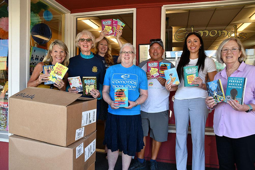 CASA Books Program CASA staff officially accept the book donation in front of the Edmonds Bookshop. From left: CASA Division Manager Joelle Kelly, Diane Buckshnis, Michelle Bear, Mary Kay Sneeringer, David Brewster, CASA Program Supervisor Lindsay Cortes, and CASA volunteer case worker Hannah Patterson. 